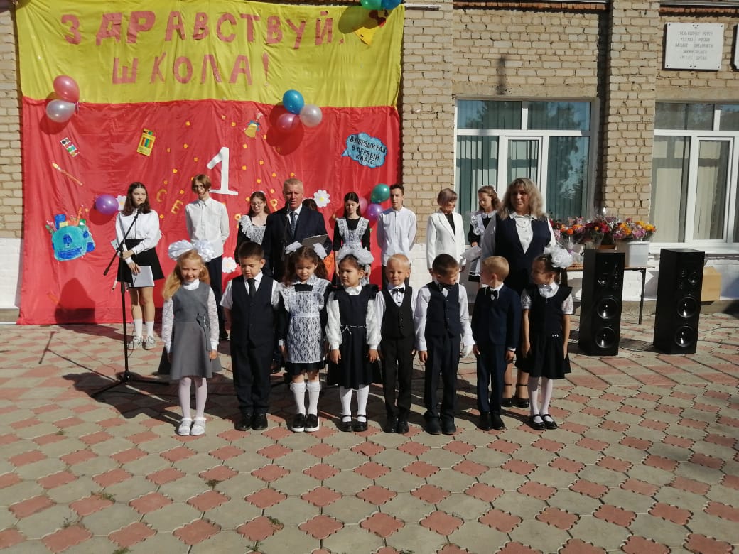 Одиннадцатиклассники и первоклашки на торжественной линейке.